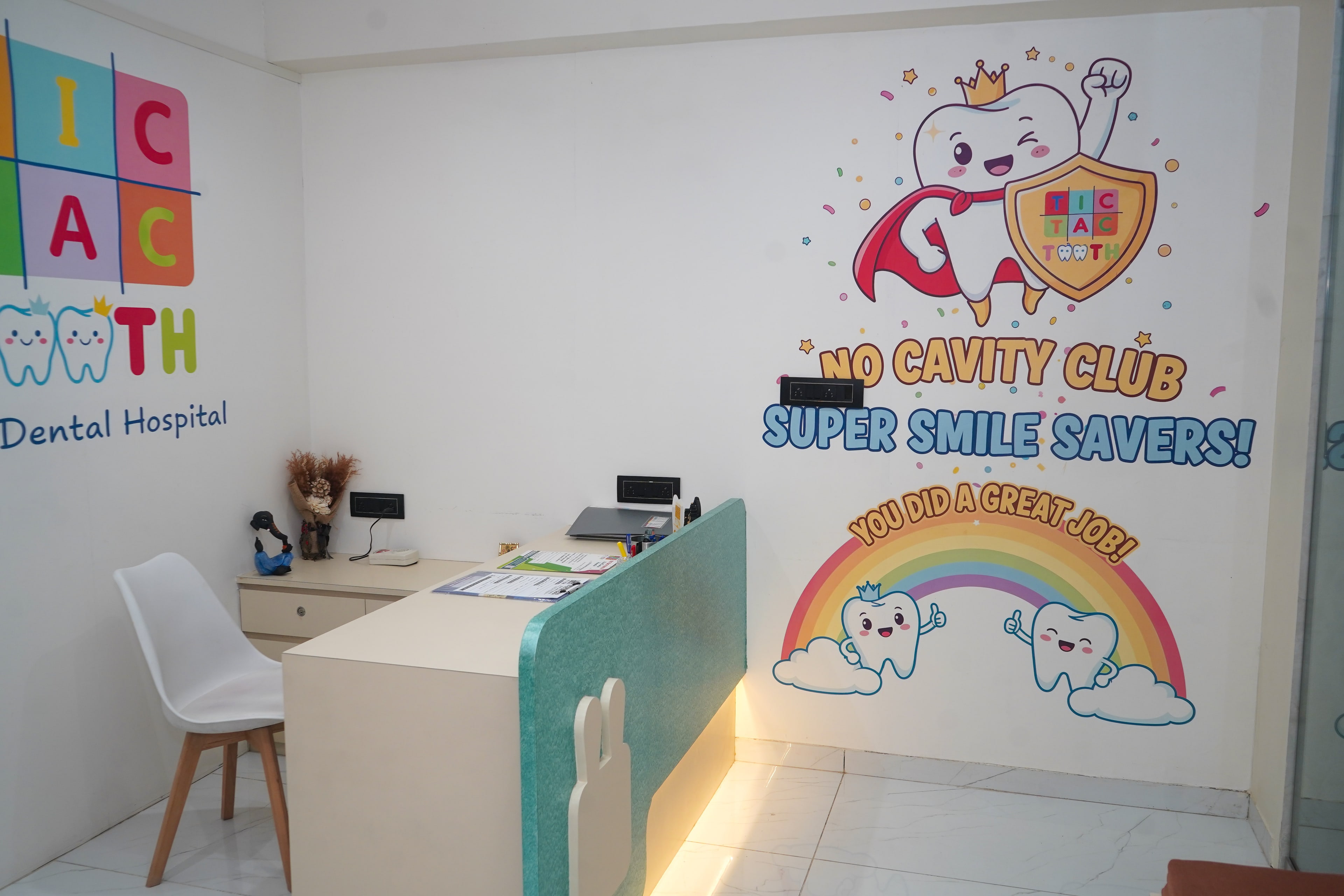 The No Cavity Club mural beside reception, a winking superhero tooth in a gold crown and red cape holding a shield with the Tic Tac Tooth logo, above 'Super Smile Savers!' and a rainbow