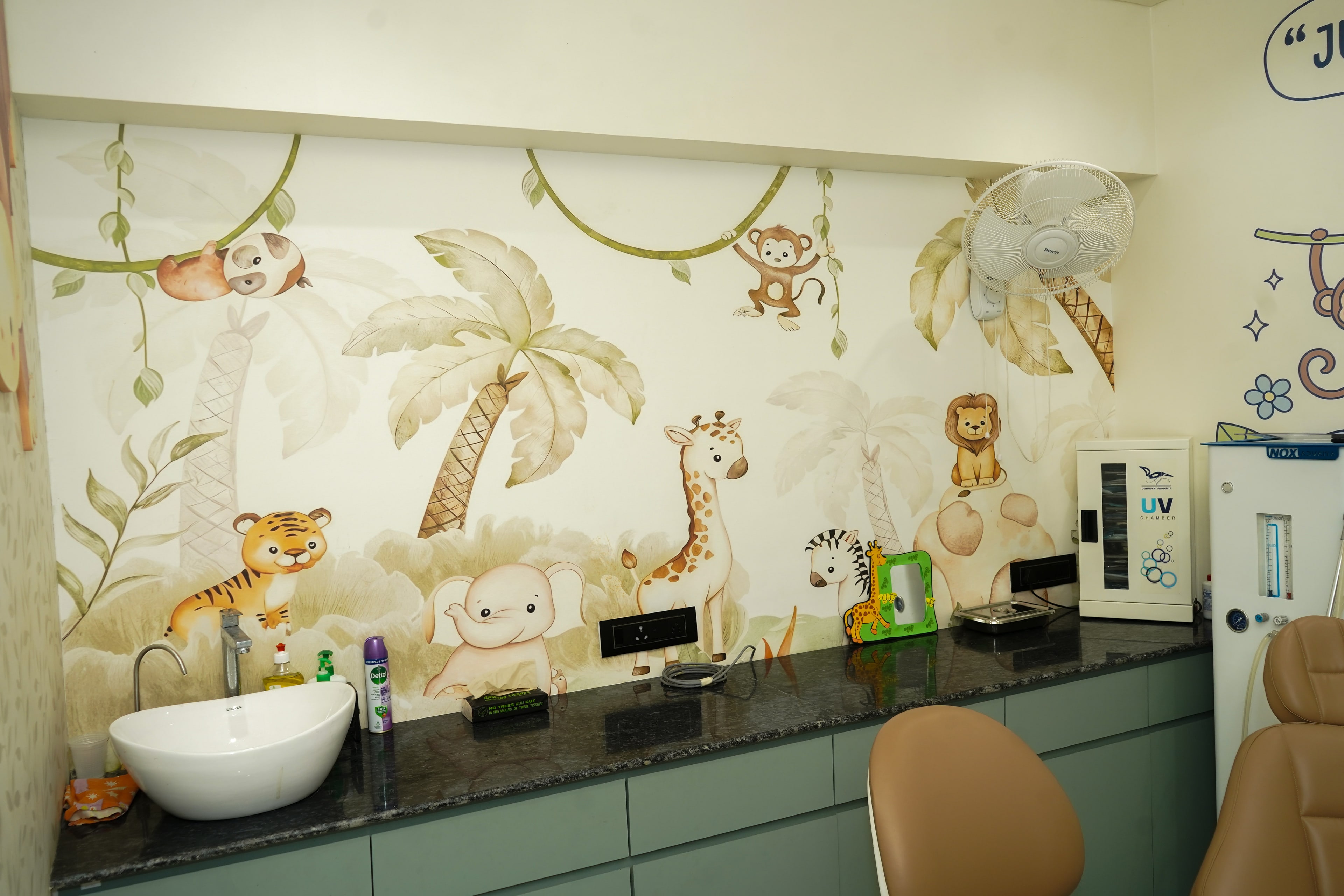 The jungle room's watercolour mural, a sloth on a vine, a monkey, a tiger, an elephant, a giraffe, a zebra and a lion on a rock among palm trees